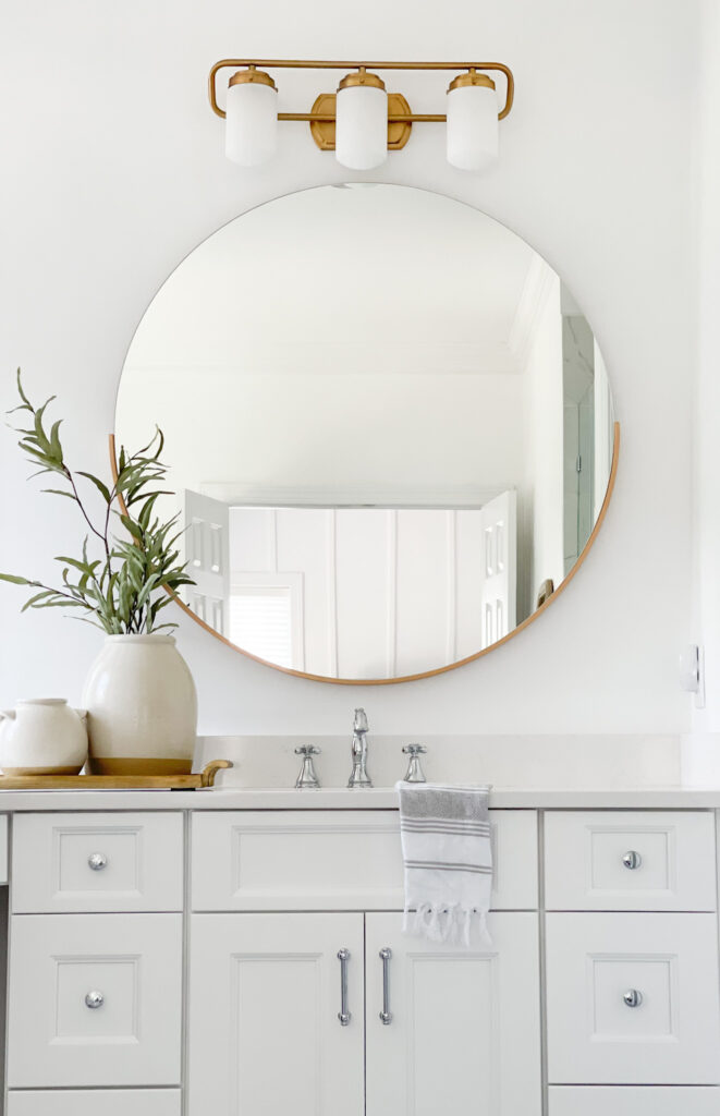 Mixed Metals with White Vanity and Round Mirror