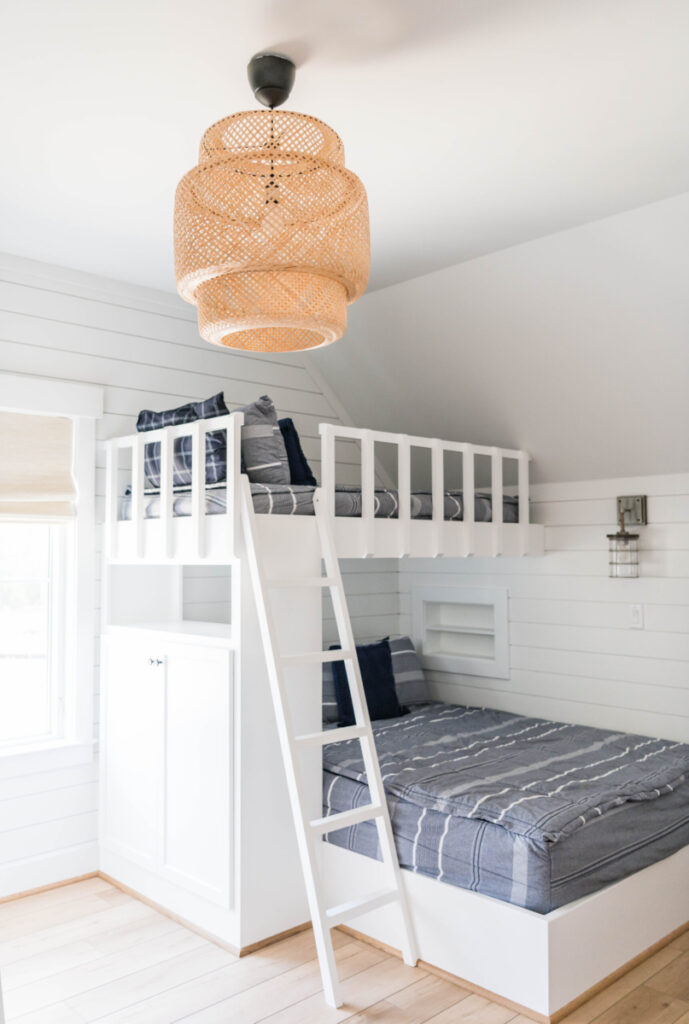 Bunk room with rattan light and coastal sconce